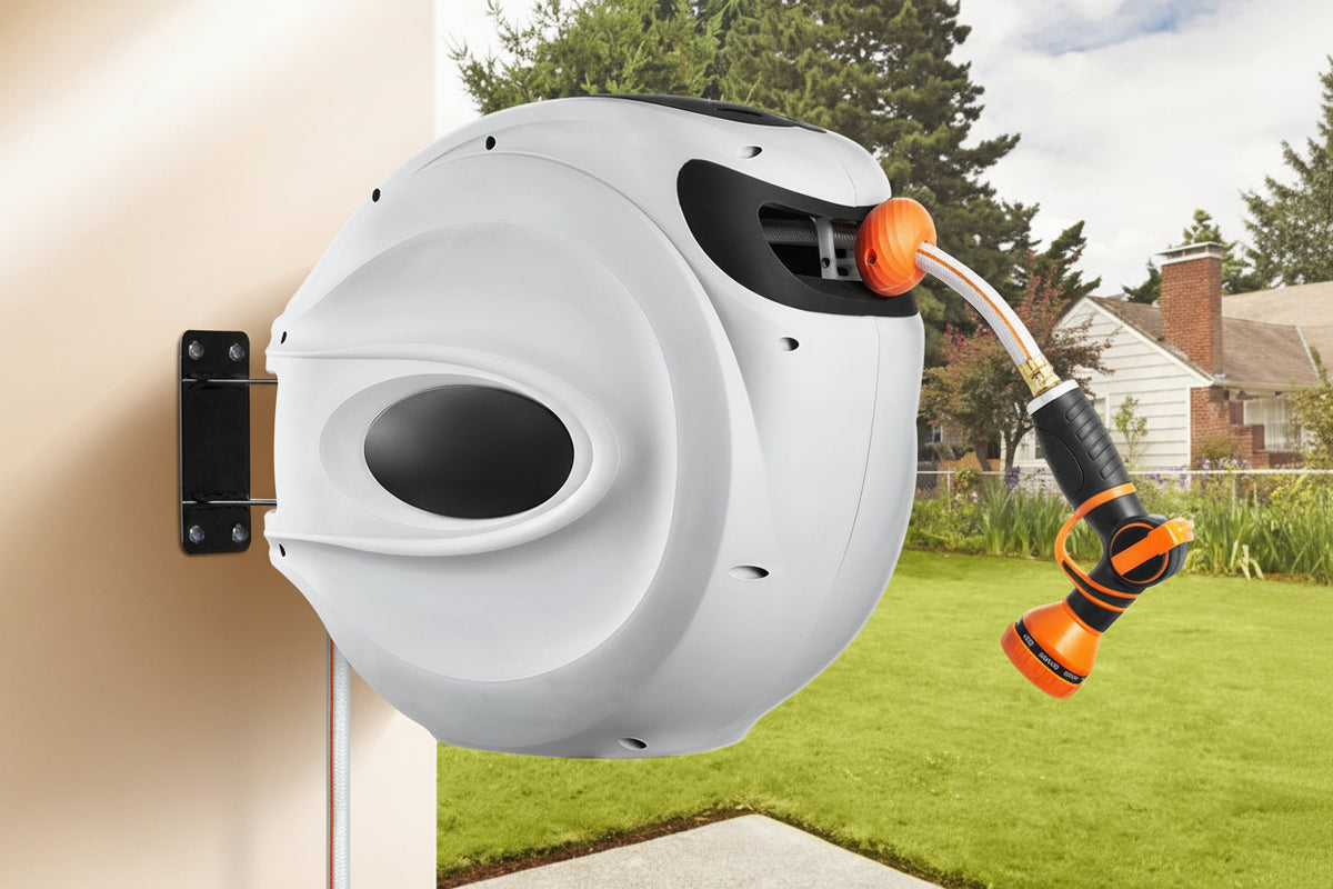 White Vevor hose reel with orange accents on a wall with a garden background
