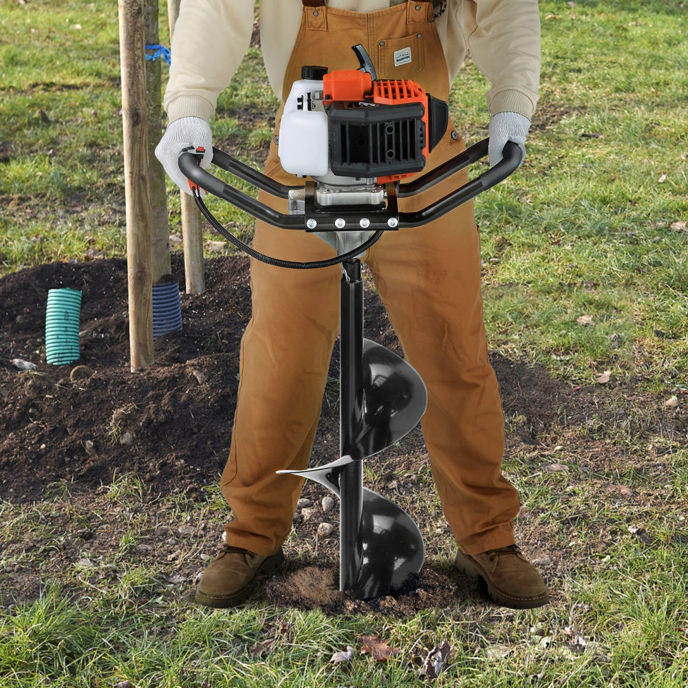 Person using a post hole digger in a garden setting