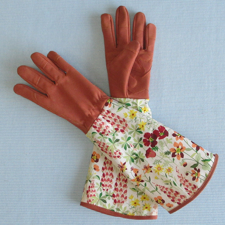 Pair of brown gardening gloves with floral cuffs on a light blue background